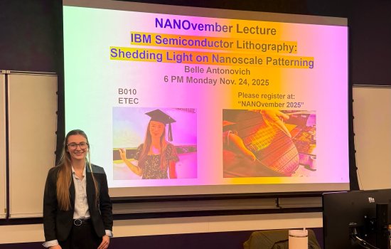 Belle Antonovich smiles in front of a big screen slide for her talk at UAlbany.