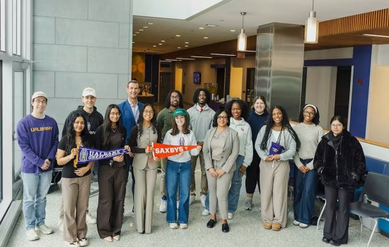 Group of students and faculty stand with Saxbys staff to celebrate the new student-led cafe coming in the fall
