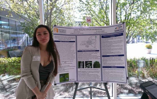 Anthropology major Anna Souls stands with her poster presentation at Showcase 2025.