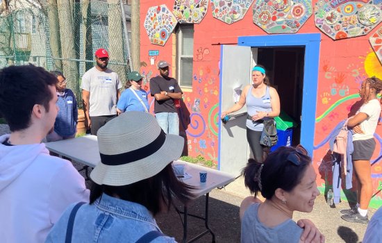 A group of volunteers stand outside the West Hill Refugee Welcome Center.