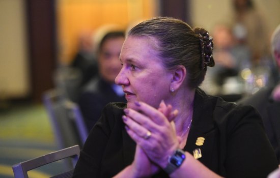 Michele Grimm applauds from her seat at an annual banquet. 
