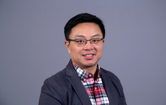 Dr. Qian smiles at the camera.