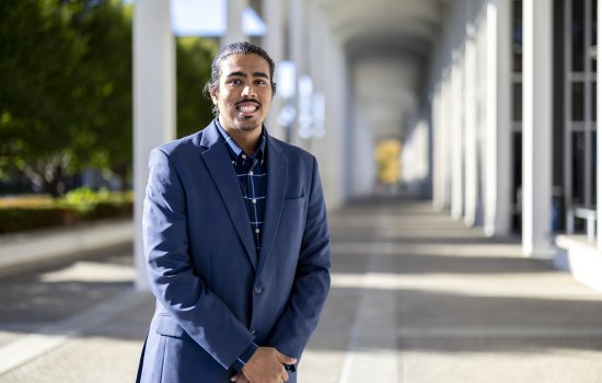 Parmesh Thakoordial stands between the columns on the Academic Podium.