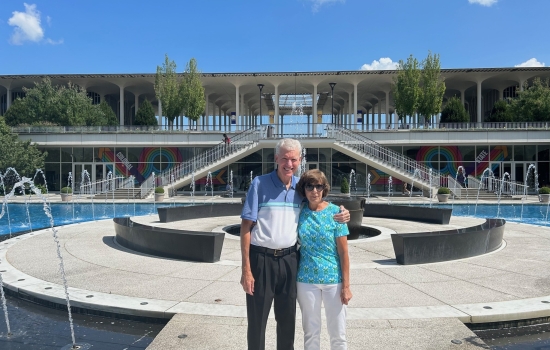Donna Brown '78 and her spouse, Ted, pose at the main fountain during a campus visit in 2023.