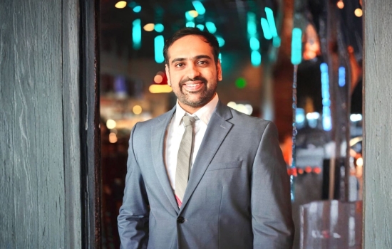 A smiling Rajas Mathkari in a gray suit with a white shirt. 