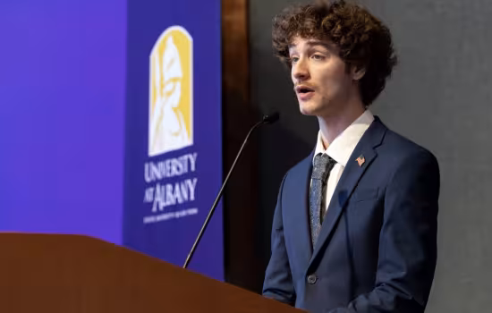 Junior Troy Serao delivers remarks from a UAlbany podium.