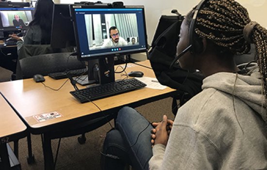 Lionel Tchatchoua Ngaleu, at right, speaks by Skype with a student from the Université de Haute-Alsace in France, one of three intercultural conversations she took part in this semester in her French Studies course. (Photo by Sarah O'Carroll)