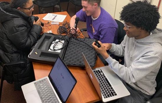 Students with laptops and microphones recording podcasts.