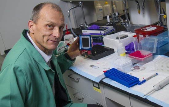 Igor Lednev holds a portable Raman spectrometer.