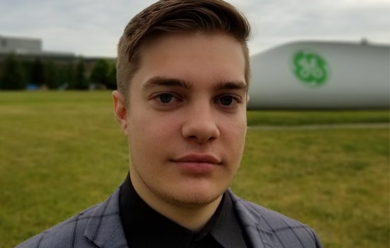 Reese Johnson in front of the wind turbine blade displayed at the Schenectady site of General Electric