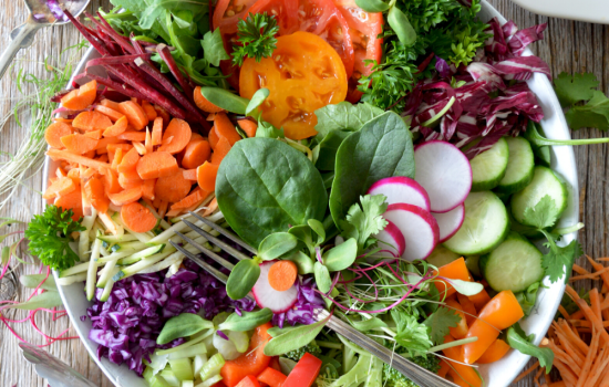 A white bowl filled with healthy salad items.