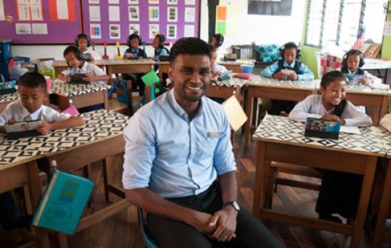Samuel Isaiah sits before his classroom of children in the Sekolah Kebangsaan Runchang school in Muadzam Shah, Pahang, Malaysia.