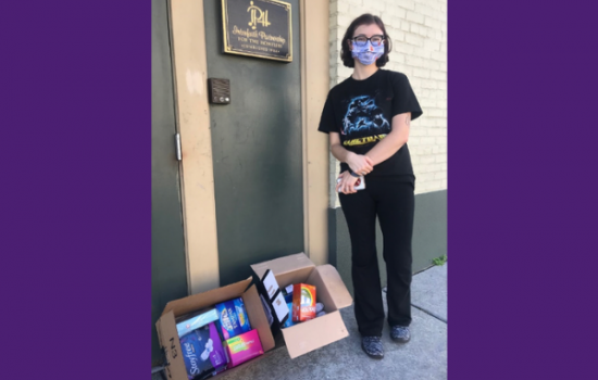 Woman wearing a face mask is smiling at camera.