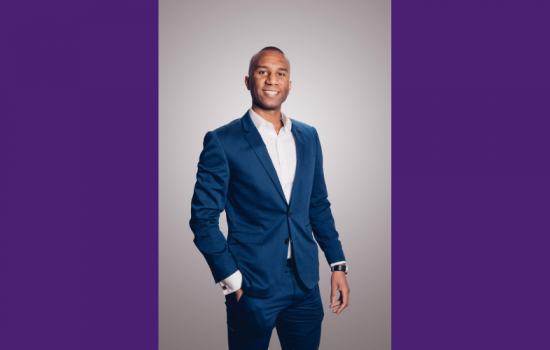 Man wearing a suit smiling at the camera.