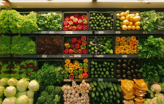 Vegetables along the wall of a grocery store.