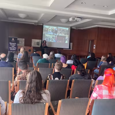 Dr. Annie Wilkinson presenting in front of an audience.