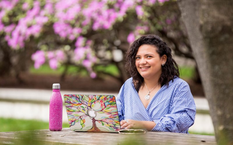UAlbany student on laptop in garden