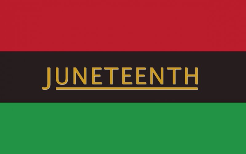 The word "Juneteenth" is seen in gold letters on a flag with horizontal bars of red, black and green