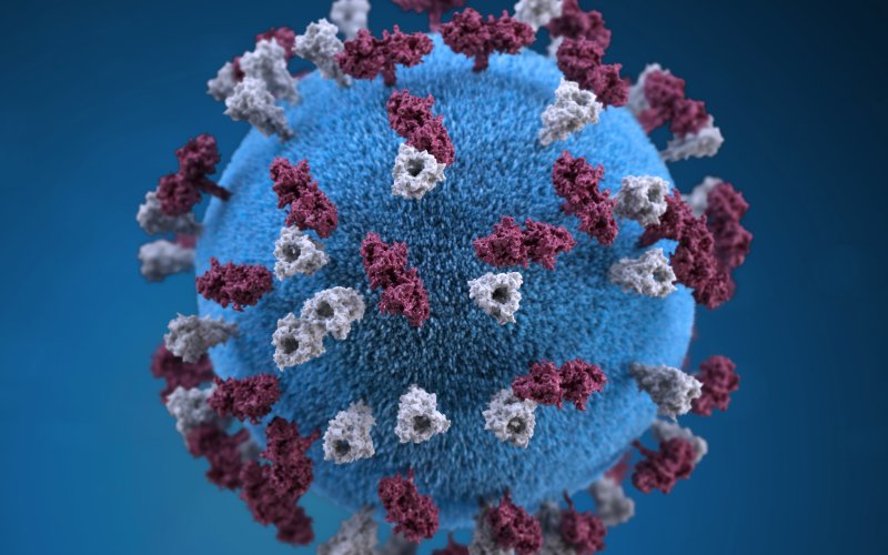 A digital rendering of a covid-19 virus - a blue sphere with red triangles on top of it.