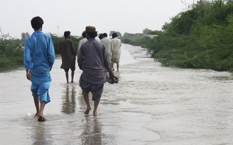 People walking through a flooded suburb in Thatta, Pakistan.