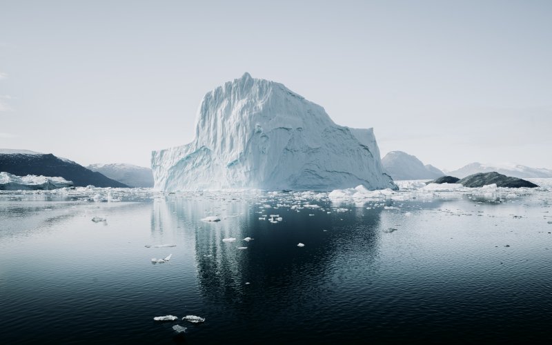 Arctic iceberg reflects on ocean sea surface.