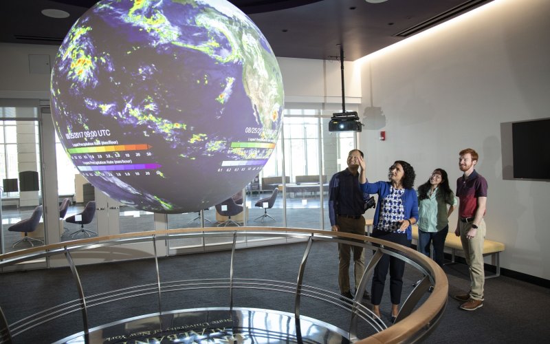 DAES faculty and students observe the "Science on a Sphere" globe inside ETEC.