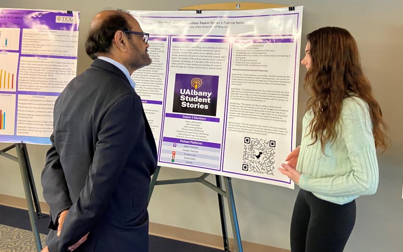 Spanish TA and PhD student Caitlin Fanning presents a research poster to the U's VP for Research & Economic Development