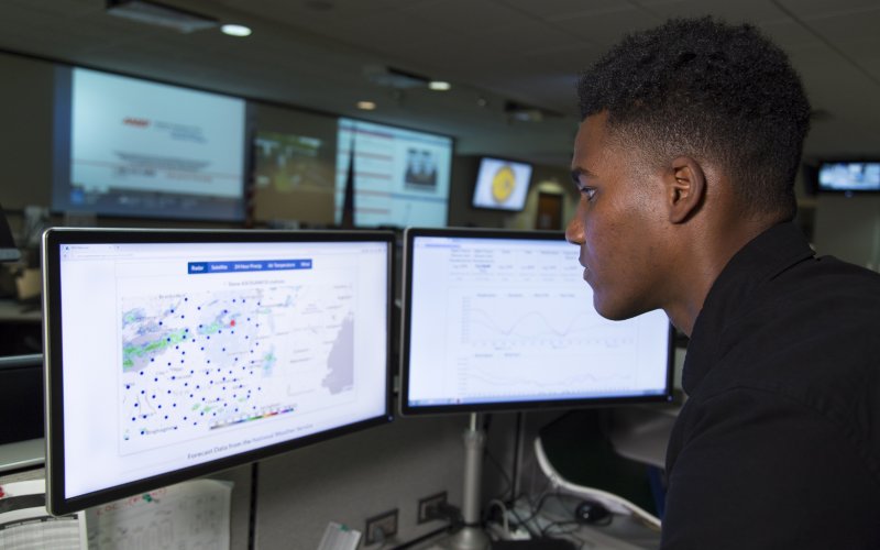 A CEHC student looks over weather data on dual monitors at the NYS DHSES Operations Center.