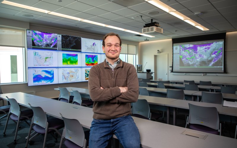 UAlbany senior John England sits with his arms crossed in the Map Room at ETEC.