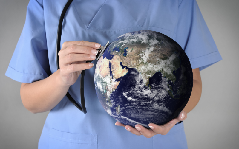A medical worker holds a globe. 