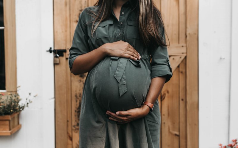 A pregnant woman holds her belly.