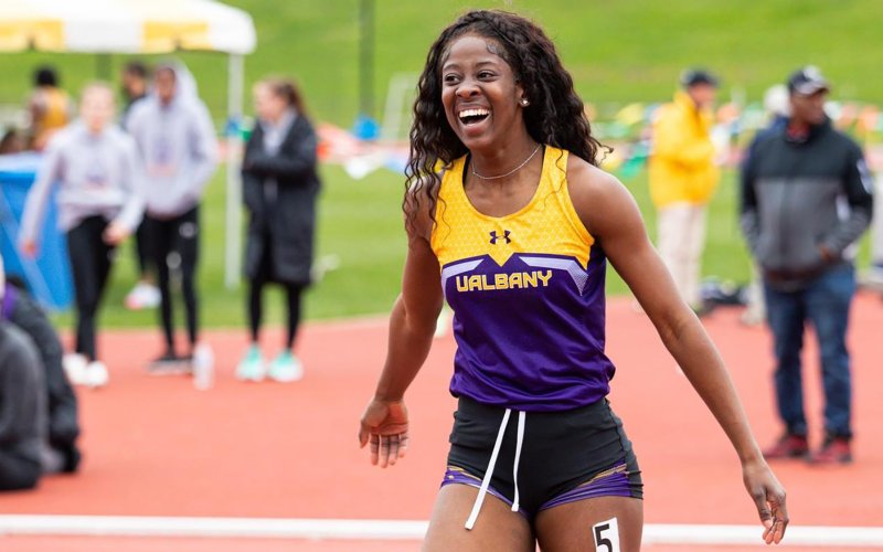 UAlbany track athlete Dominique Clarke smiles following an outdoor sprint event in 2022.