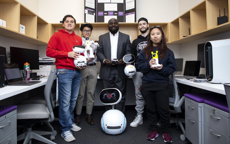 Professor Benjamin Yankson and CEHC student interns display smart devices they are testing at the Hack-IoT Lab. 