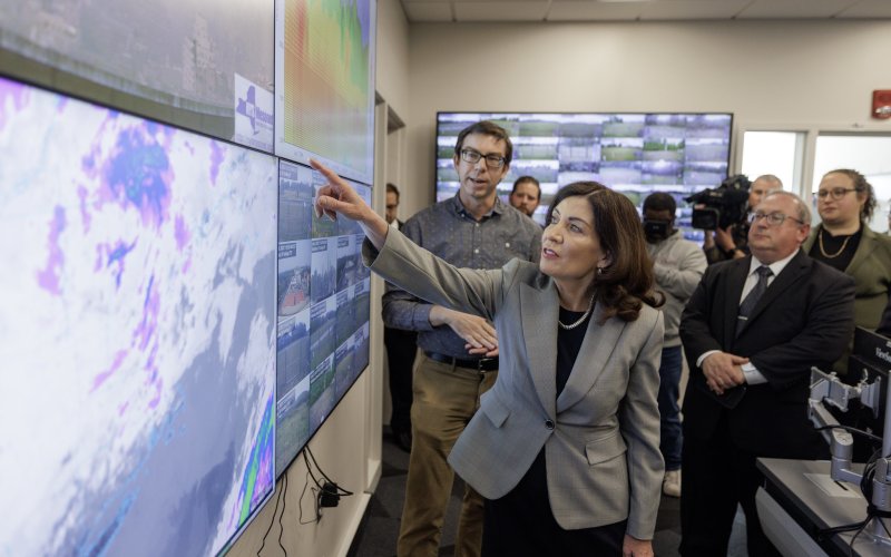 Gov. Kathy Hochul points at an air quality monitoring screen inside the NYS Mesonet operations center at ETEC.