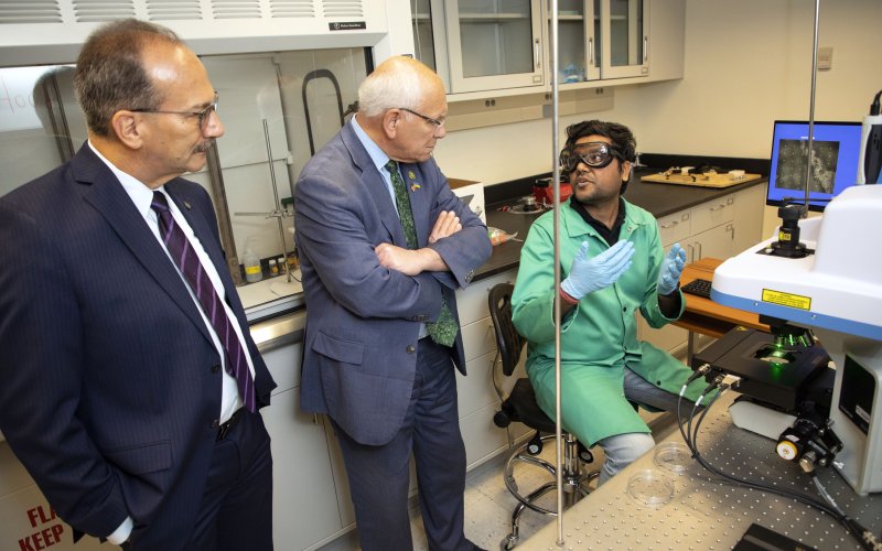 President Rodriguez and Congressman Tonko view a demo of the Lednev lab's screening tool, led by UAlbany PhD student Bhavik Vyas.