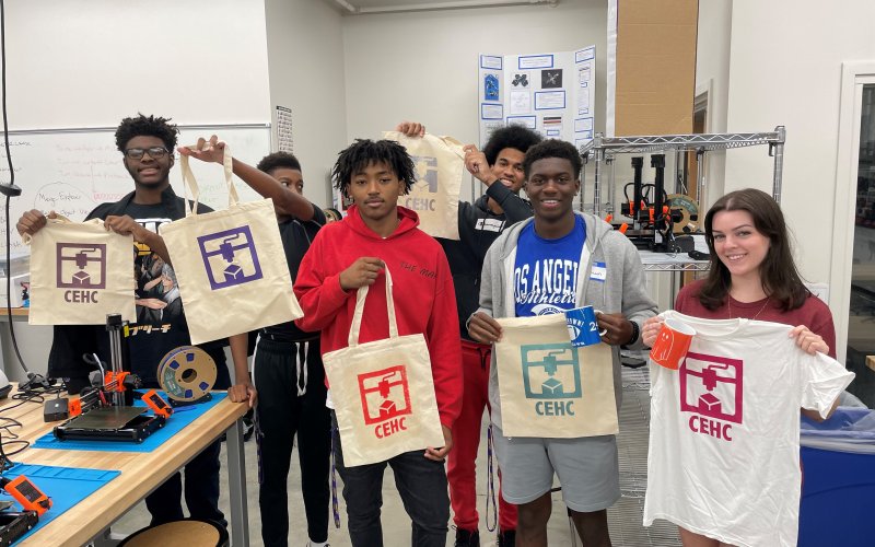Several students involved in STEP pose for a photo with their tote bags.