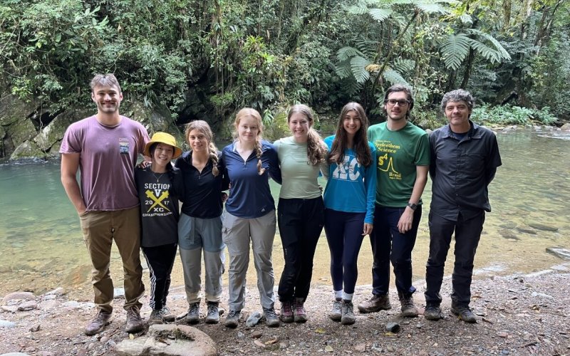 Mathias Vuille (far right) and seven DAES students stand outside of a cave at PETAR State Park in São Paulo, Brazil.