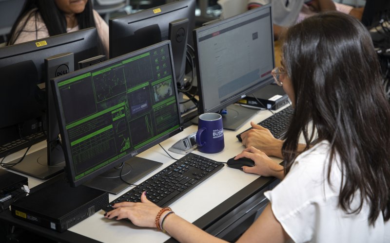 A female student works at a cybersecurity computer workstation inside the digital forensics lab at UAlbany.
