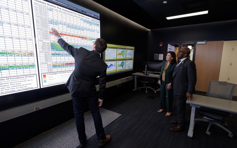 Nick Bassill points to a roadway weather risk assessment map during a visit to the xCITE Lab with Gov. Kathy Hochul and Al Roker of the TODAY Show.