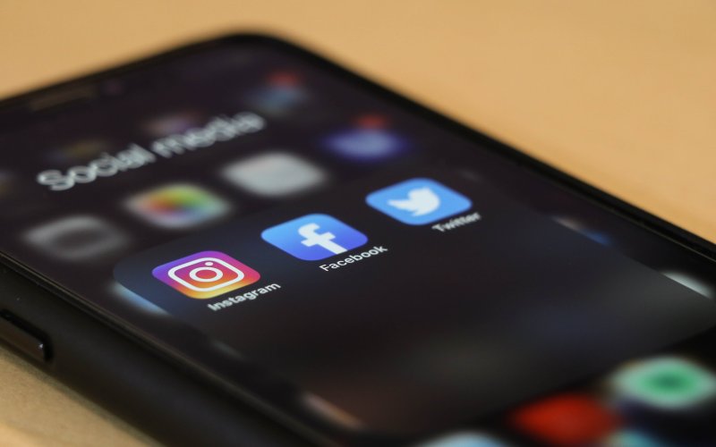 A phone shows three social media icons.