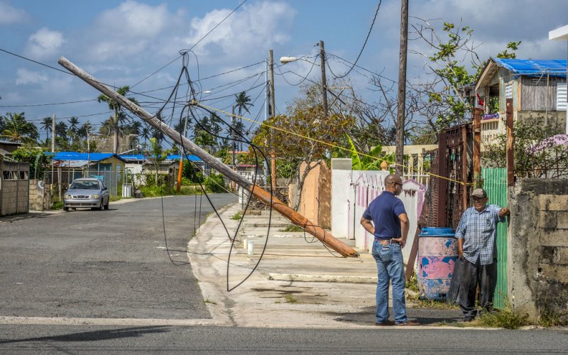 Residents in the coastal town of Loiza, Puerto Rico stand in front of a downed power line in the aftermath of Hurricane Maria.