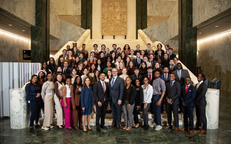 UAlbany student interns join for a class photo on a set of stairs inside the Legislative Office Building.