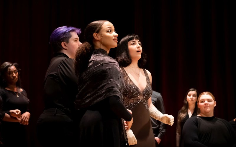 Young people in fancy clothes perform at a vocal recital