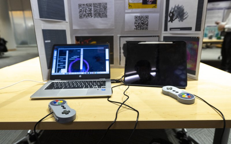 Laptops connecting to gaming controllers sit on a table inside the ETEC shared training room.