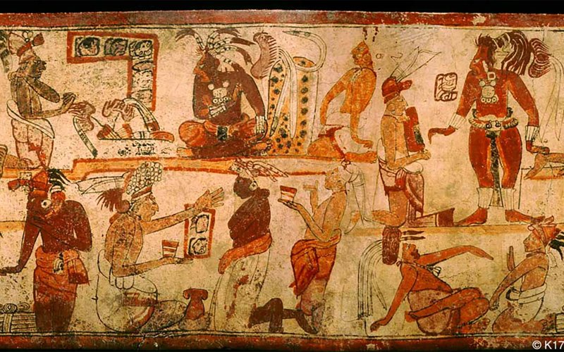 A painted late classic-period Maya royal court scene depicting tribute payments, including dish with bundled tallies in the top left of the image next to the king sitting on his throne. 