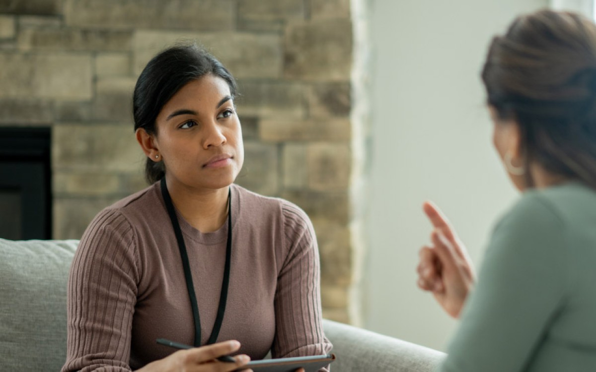 A smiling counselor meets with a client.