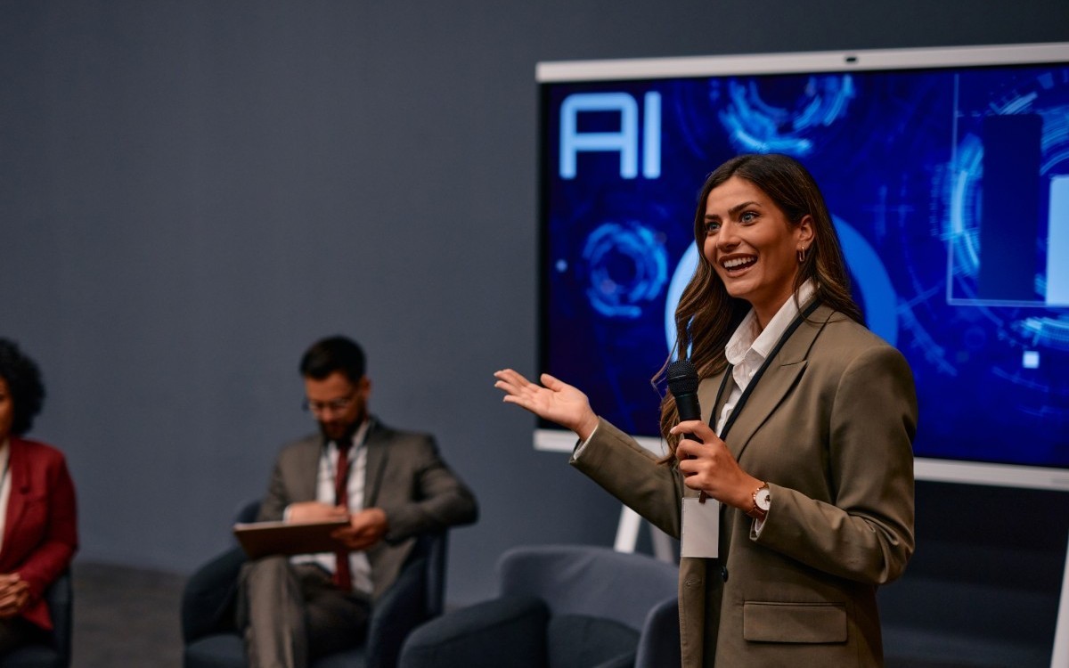 A public relations specialist answers questions at a press conference.