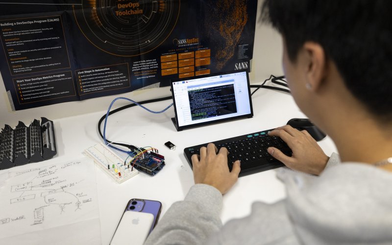 A student reviews code on a tablet from the Cyber Resilient Interdependent Systems & Infrastructure Solutions Lab at ETEC. (photo by Patrick Dodson)