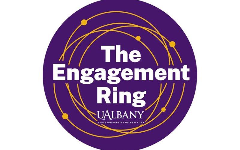 round purple logo with intersecting gold rings and the words "The Engagement Ring UAlbany"