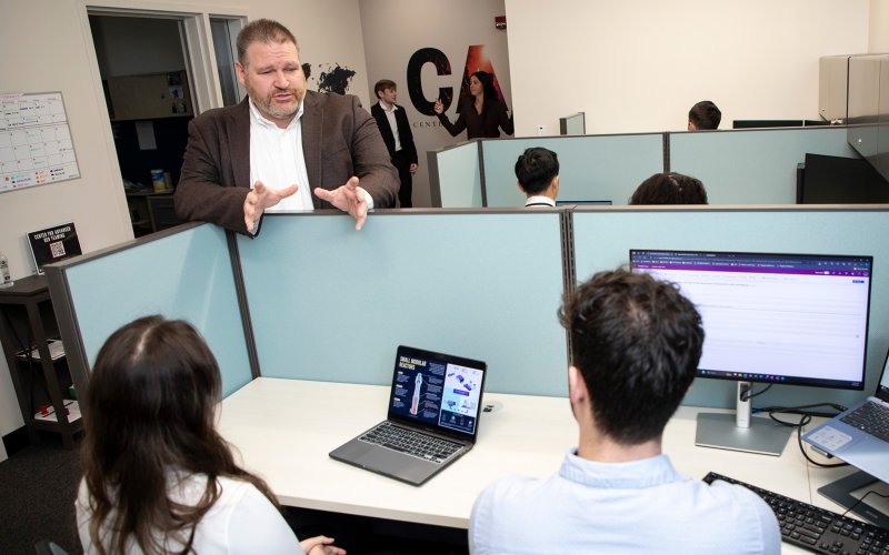 Brandon Behlendorf talks with students inside the Center for Advanced Red Teaming at ETEC.